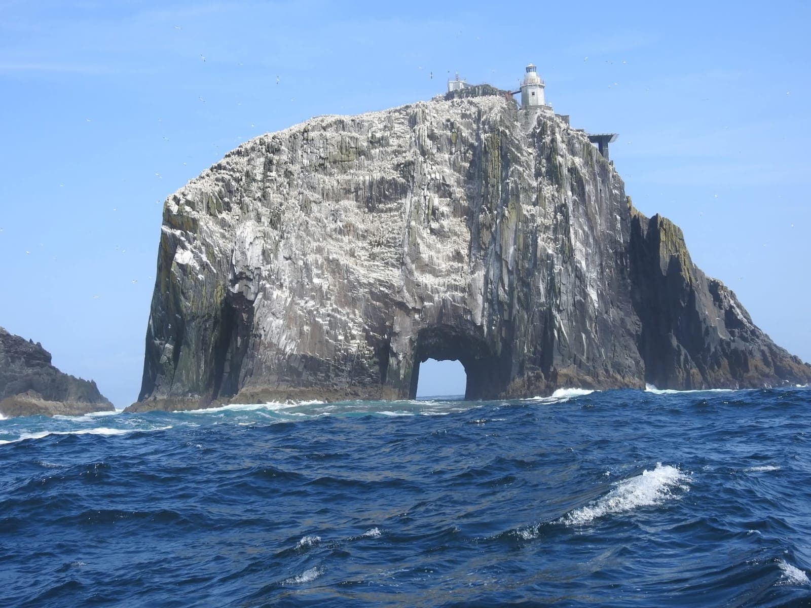 Lighthouse on a sea-arched rock off the Kerry coast